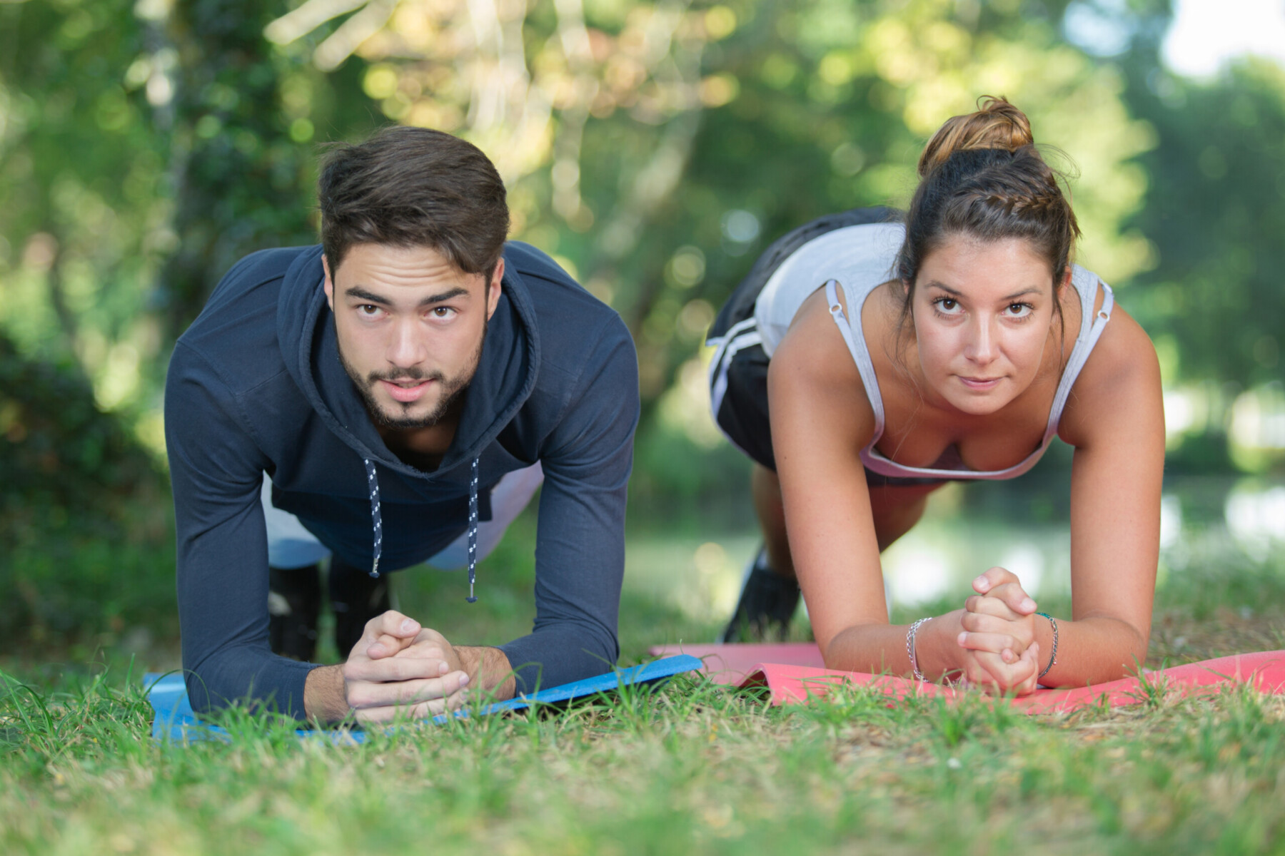 sport man and woman in training in green park